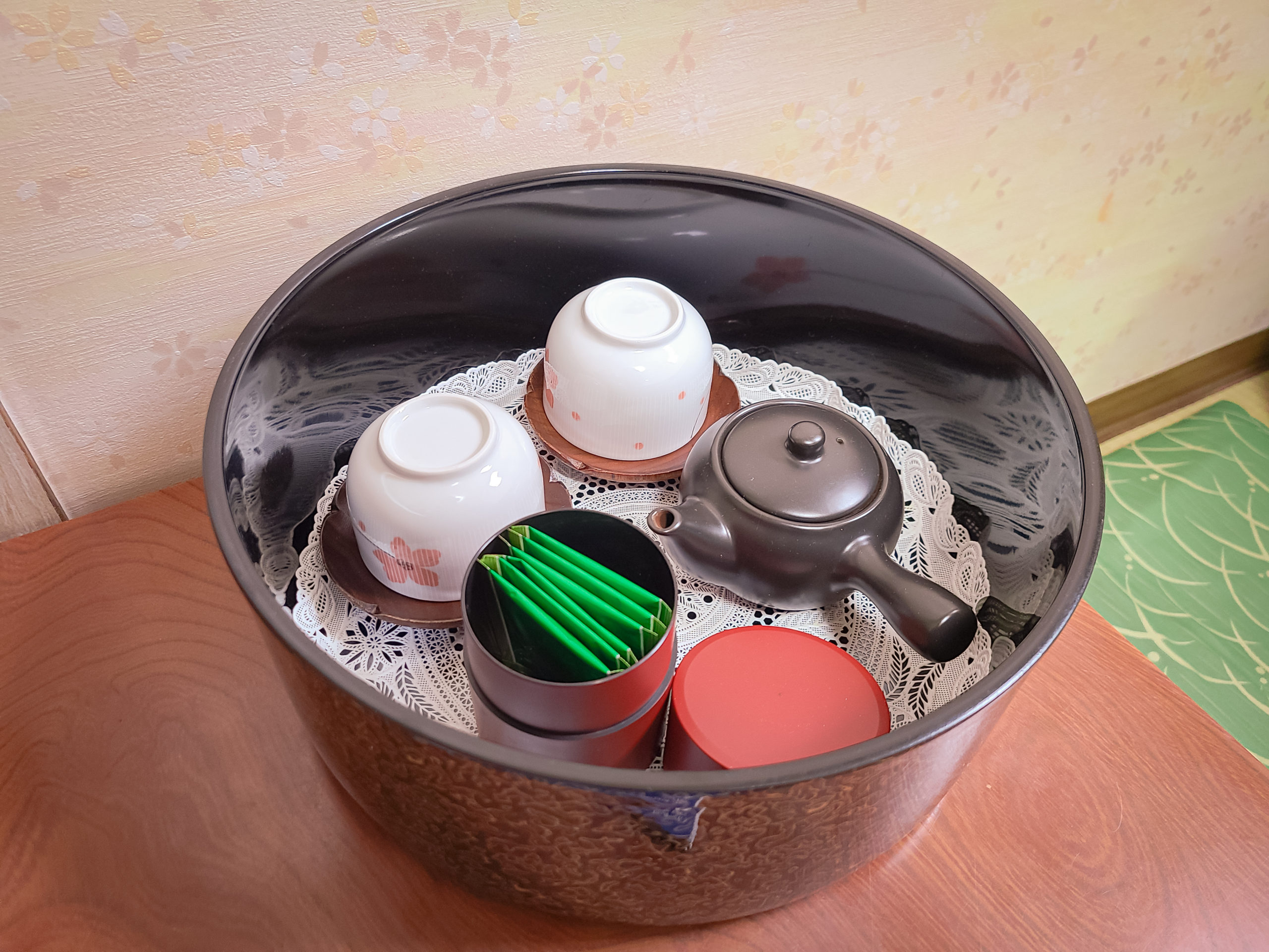 A container with green tea and cups