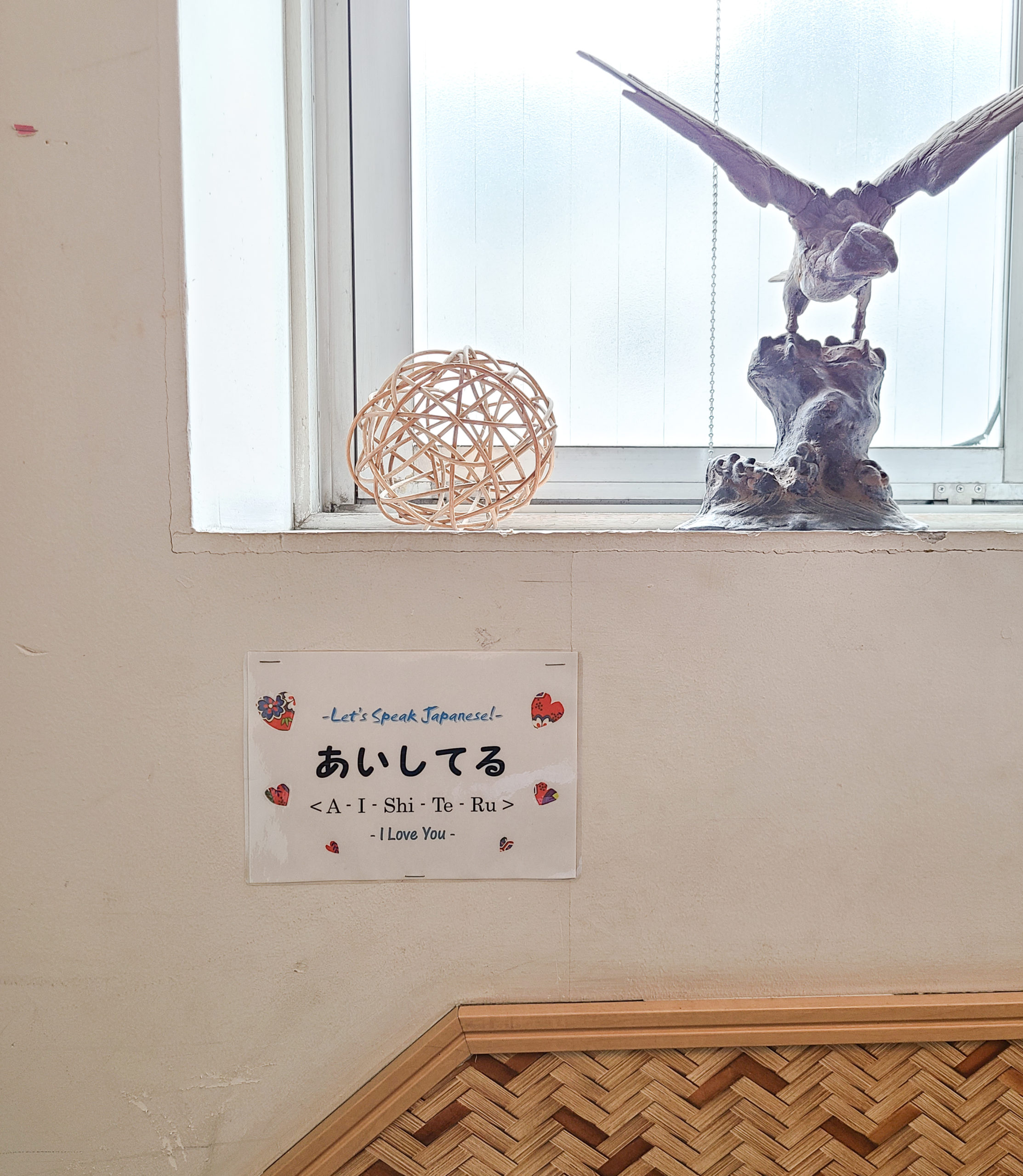 A sign on the wall explaining simple Japanese vocabulary—this one is the word for “I love you”
