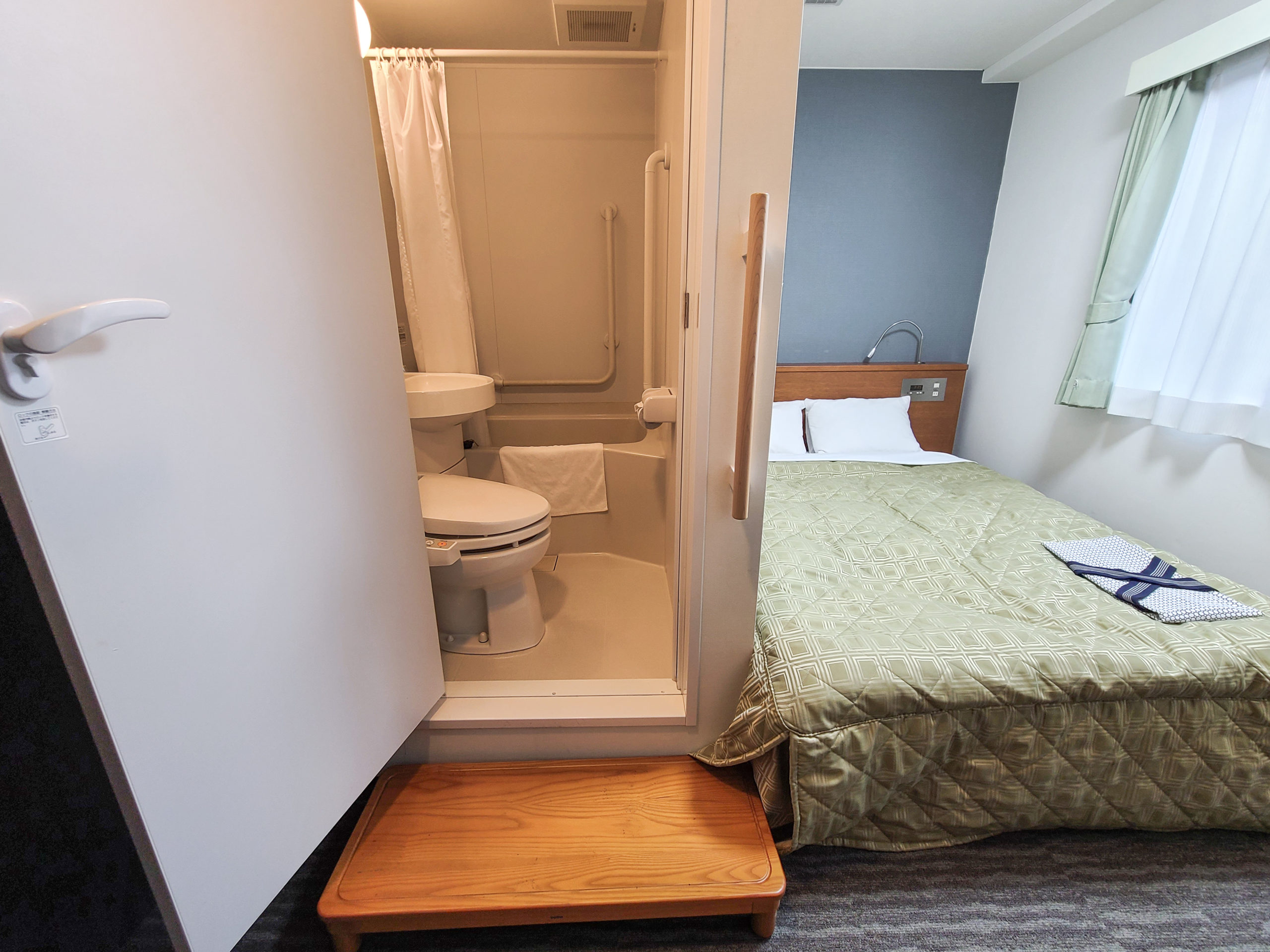 This room has a handrail and stepping stool to make access to the raised unit bath easier
