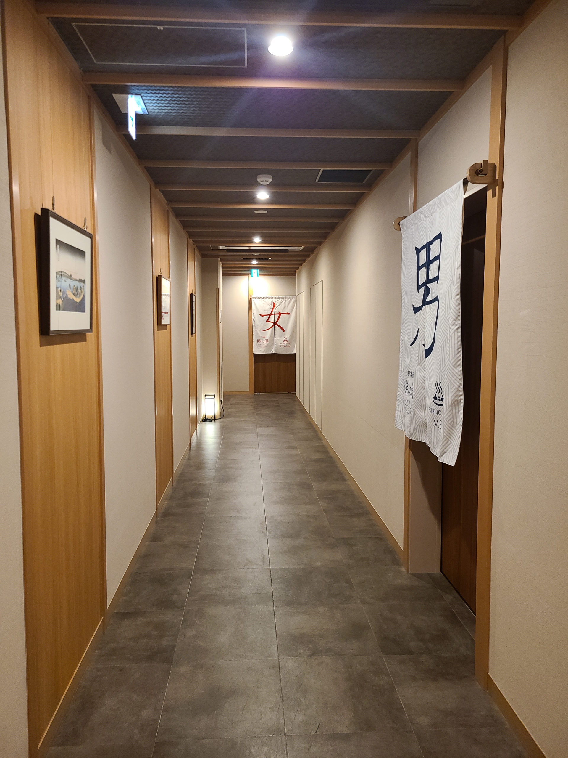 The automatic door featuring traditional Japanese woodwork leads to the public bath hallway 