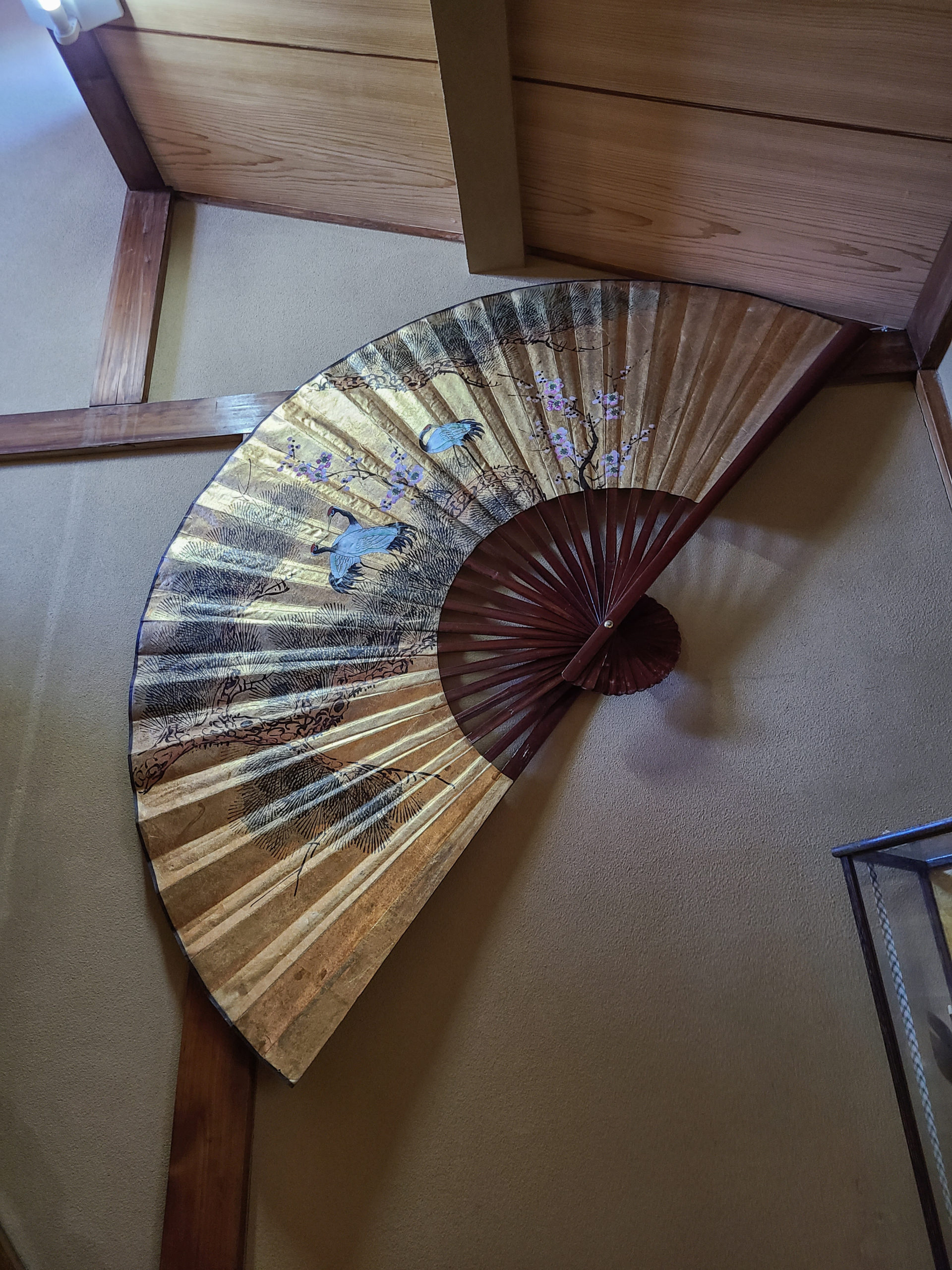 A large fan hangs in the staircase, and small antiques decorate the hall