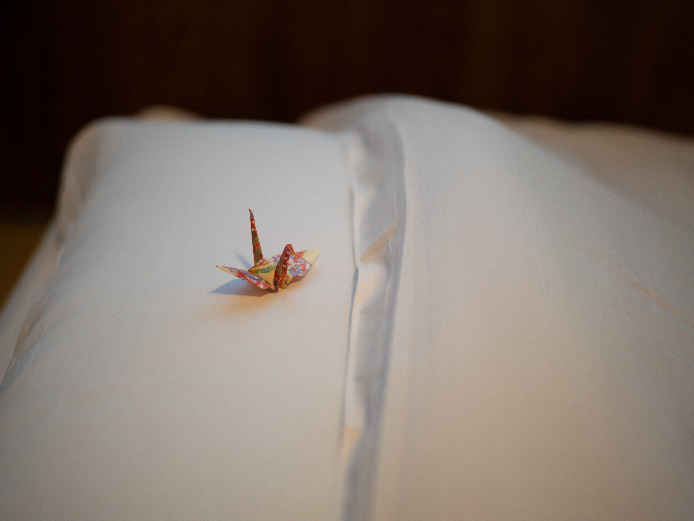 A folded origami crane on the guest’s pillow—a touch of Sawanoya’s omotenashi (hospitality)