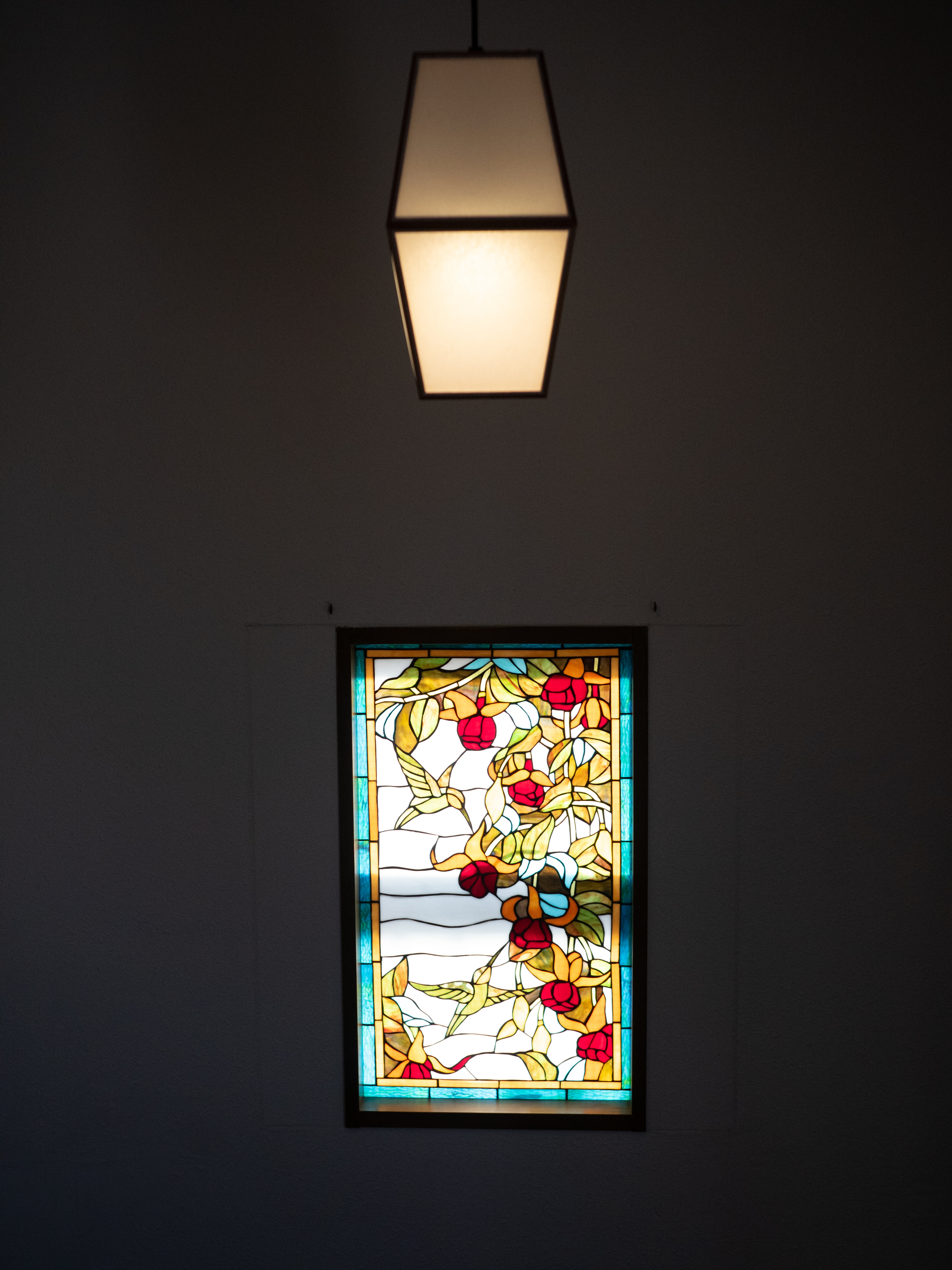 Stained glass window in the stairwell—a stark contrast to the overall wa-taste