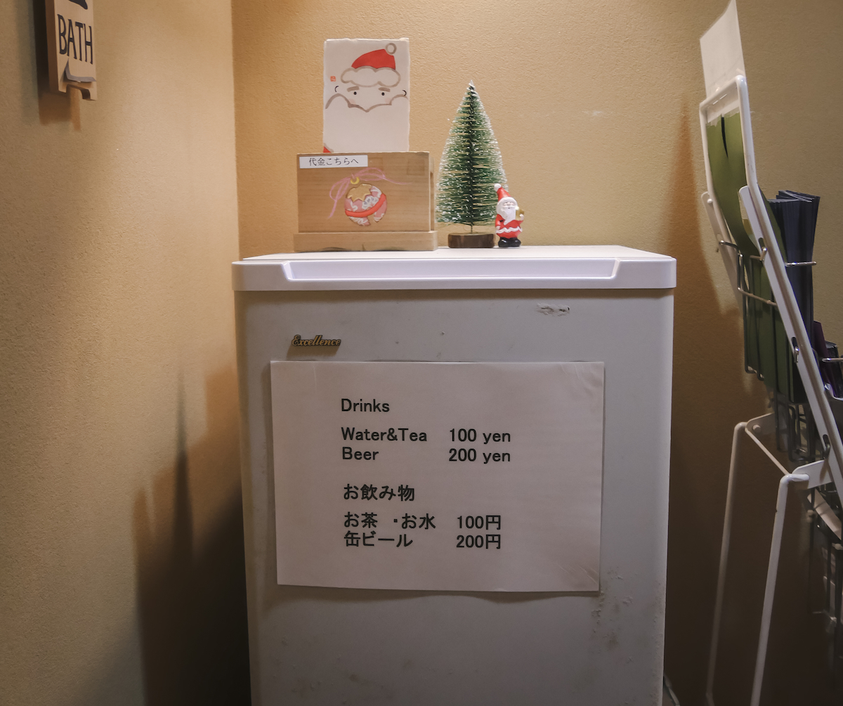 a small refrigerator with a sign showing prices